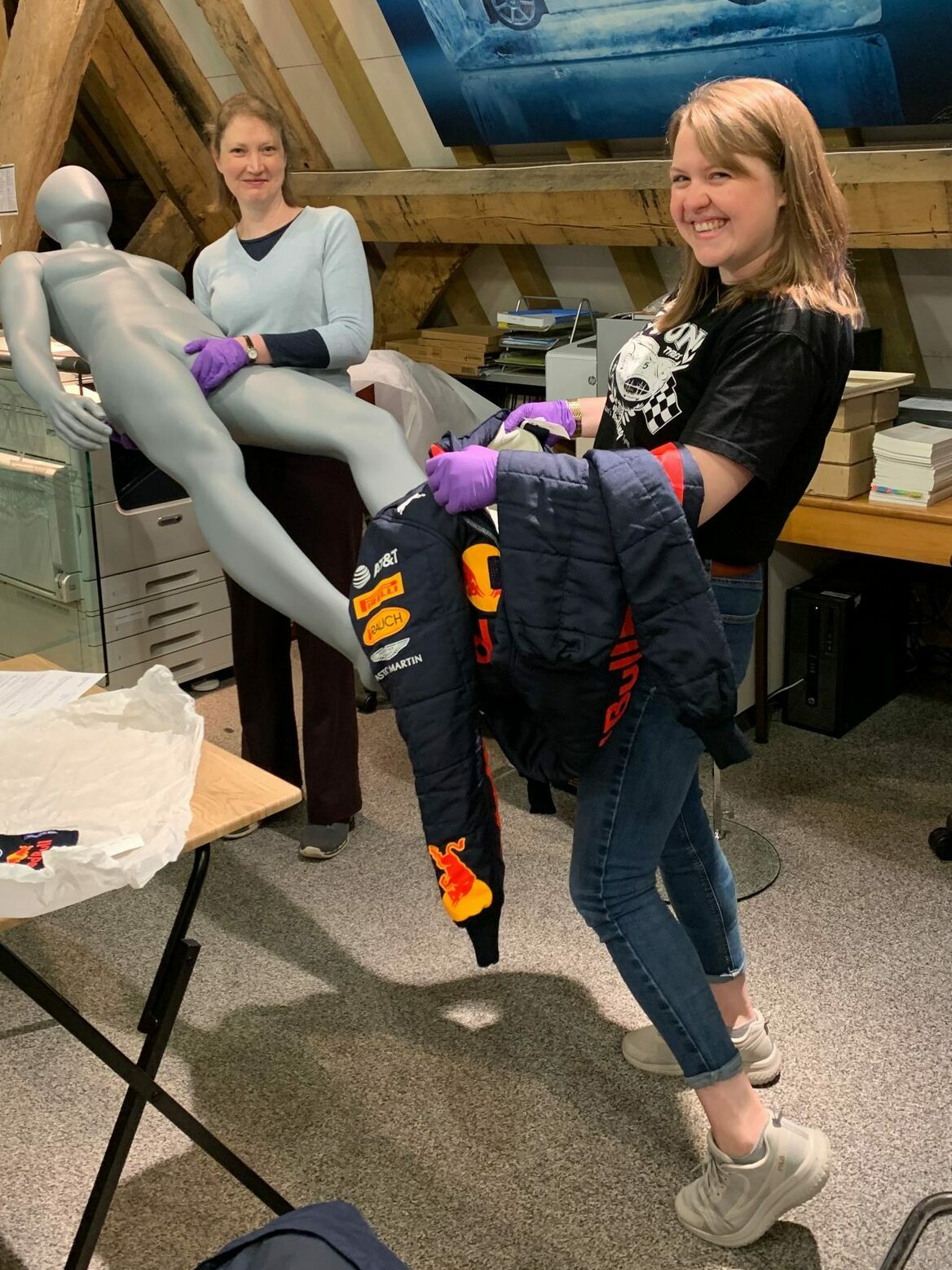 Two members of staff dress a costume mannequin