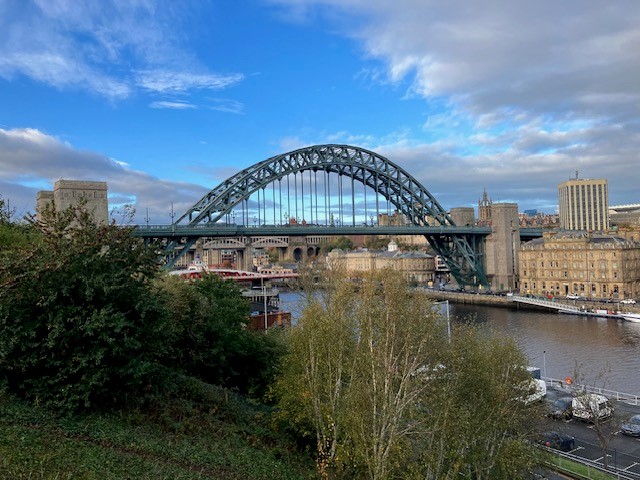 The image shows the Tyne Bridge with Newcastle city in the background