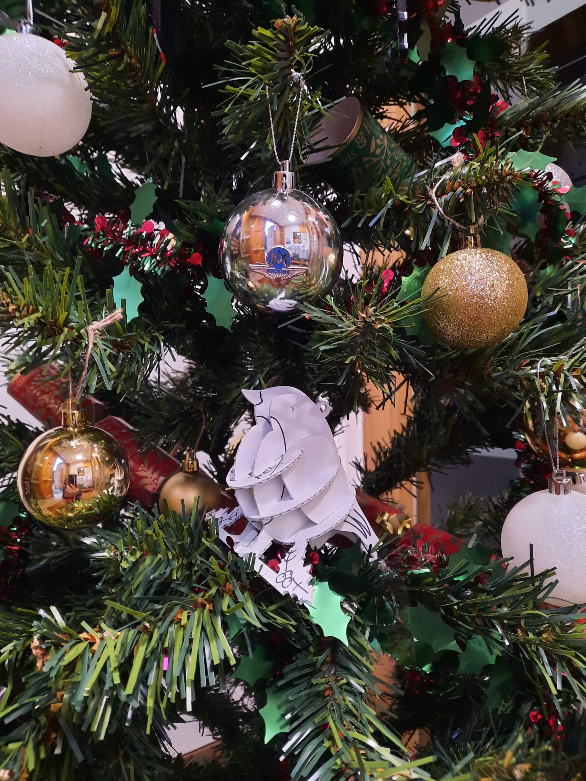 Close up image of a Christmas tree with an AMHT bauble and a cardboard robin made by Preservation Equipment Limited