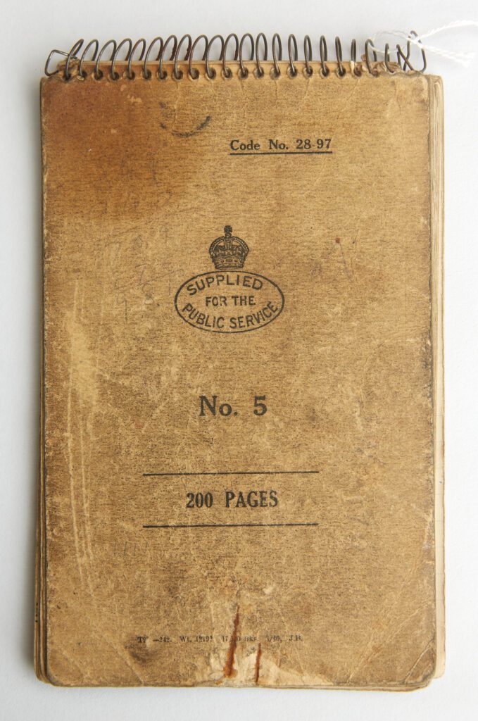 Image of the front of 'Jock' Horsfall's wartime notebook, which he used from 1940-1941. It is a small brown notebook with wire binding at the top and is aged and used